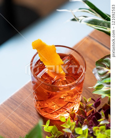 Negroni cocktail standing on table with orange peel garnish 121092583