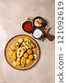 Delicious fried appetizers platter with dipping sauces on table 121092619