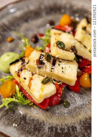 Delicious grilled halloumi cheese salad with a side of pesto sauce 121092621