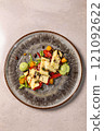 Grilled halloumi cheese salad with vegetables and pesto dressing 121092622