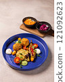 Gourmet vegan dish served on blue plate with side dishes 121092623
