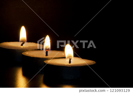 Candles shining in the dark representing religious prayer moment with customizable space for message, text or ideas. 121093129