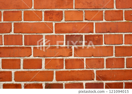 Closeup of a strong red brick wall and copy space on exterior of a home, house or city building. Texture and detail background of rough architecture construction design of facebrick on old structure 121094015