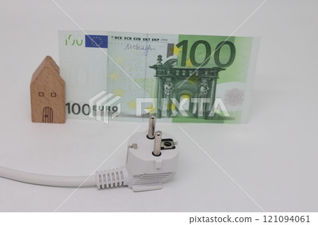 White electric cable and banknotes against the background of a toy model house 121094061