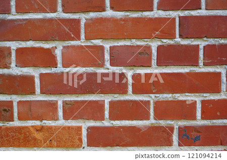Background. Closeup of a brick wall with cement and rough texture on a home or house. Details of modern architecture on of a residence or building as a background. Solid red brickwork on a wall. 121094214