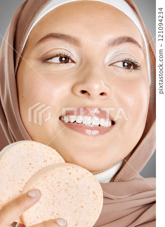 Young Arabic girl in hijaab with a smile. A beautiful middle-eastern Muslim lady wearing the abaya. .Close up of an Arabian woman with makeup puff in a strict cultural outfit and elegant appearance. 121094234