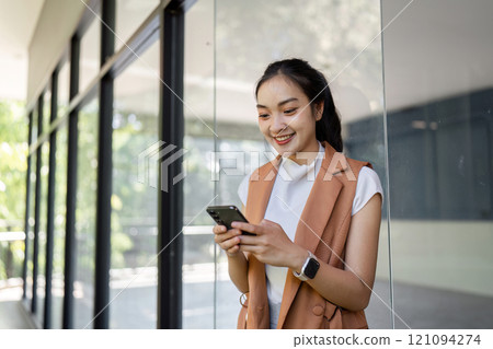 Young woman engaged with smartphone modern office space portrait bright environment casual viewpoint digital interaction Young woman engaged with smartphone modern office space portrait bright environment casual viewpoint digital interaction 121094274