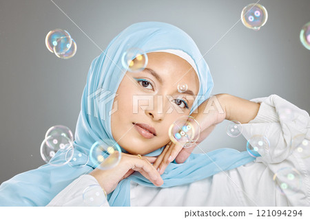 Portrait of a beautiful muslim woman wearing blue hijab headscarf against grey background. Arab female in a happy daydream and fantasy surrounded by the pure delight and innocence of playful bubbles Portrait of a beautiful muslim woman wearing blue hijab headscarf against grey background. Arab female in a happy daydream and fantasy surrounded by the pure delight and innocence of playful bubbles 121094294