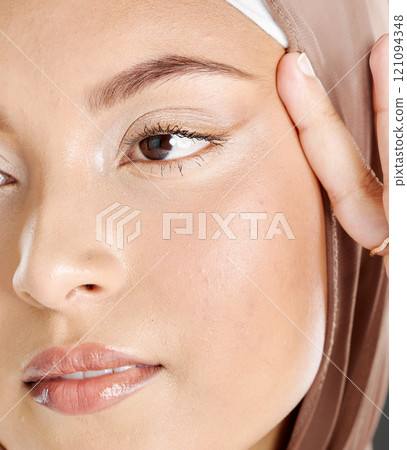 Face of a beautiful Muslim woman wearing a brown headscarf and lifting the skin around her eyes. Headshot of hijab lady contemplating eyelift surgery for a more youthful and wrinkle free appearance Face of a beautiful Muslim woman wearing a brown headscarf and lifting the skin around her eyes. Headshot of hijab lady contemplating eyelift surgery for a more youthful and wrinkle free appearance 121094348