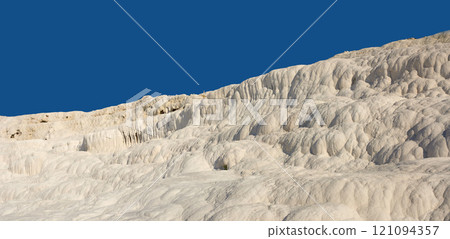 Landscape of the Travertine pools and terraces in Pamukkale Turkey. Desert sand with textured pattern against a blue sky. Tourism holiday destination at rock cotton castle location during hot springs Landscape of the Travertine pools and terraces in Pamukkale Turkey. Desert sand with textured pattern against a blue sky. Tourism holiday destination at rock cotton castle location during hot springs 121094357