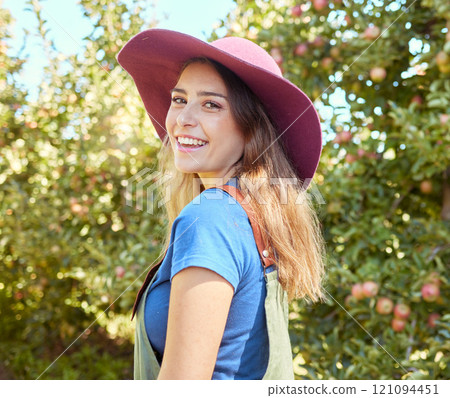 Portrait of smiling apple farmer standing alone on her farm. Happy woman surrounded by fresh fruit and produce on a remote rural and sustainable orchard estate. Agriculture getting ready for harvest 121094451