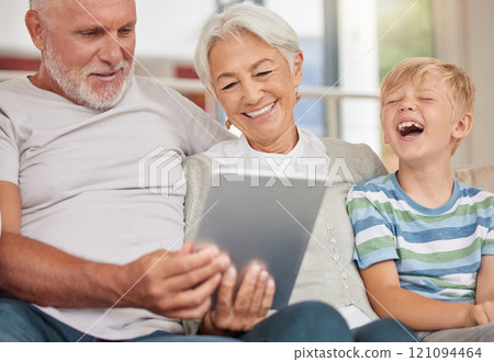 A happy mature couple bonding with their grandchild while babysitting and using a digital tablet for video call at home. Grandparents relaxing with their cute little grandson and browsing A happy mature couple bonding with their grandchild while babysitting and using a digital tablet for video call at home. Grandparents relaxing with their cute little grandson and browsing 121094464