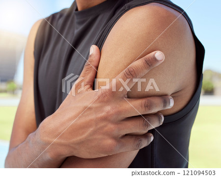 Closeup of african american sportsman suffering from shoulder pain while training. Zoomed in on unknown black man holding and rubbing sore arm with. Overworking muscles causing tension Closeup of african american sportsman suffering from shoulder pain while training. Zoomed in on unknown black man holding and rubbing sore arm with. Overworking muscles causing tension 121094503