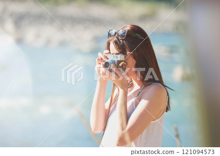 Camera, photograph and travel with hiker woman in nature for adventure or journey in summer. Forest, memories and nature hiking with tourist person outdoor in environment for holiday or vacation 121094573
