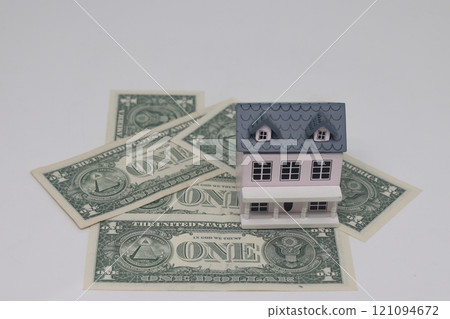 Wooden house on a stack of dollar money banknotes. concept of buying a sale Wooden house on a stack of dollar money banknotes. concept of buying a sale 121094672