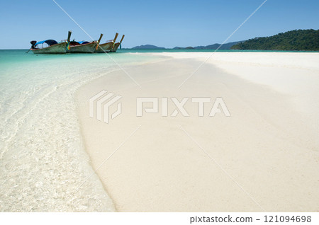 Ocean, sky and sand on beach with boat on shore, travel and tourism with holiday destination landscape. Transport, vessel and tropical island for adventure, nature outdoor and trip to Thailand 121094698