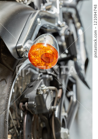 An orange turning light, signal and indicator on a shiny black motorbike. Closeup detailed texture of warning bulb used for road safety, precaution when riding on a highway or street. Safe motorists An orange turning light, signal and indicator on a shiny black motorbike. Closeup detailed texture of warning bulb used for road safety, precaution when riding on a highway or street. Safe motorists 121094748