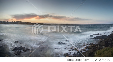 Vivid sunset over a calm ocean horizon, blending vibrant orange and blue hues, evoking serenity Vivid sunset over a calm ocean horizon, blending vibrant orange and blue hues, evoking serenity 121094820