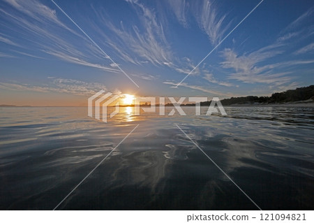 Vivid sunset over a calm ocean horizon, blending vibrant orange and blue hues, evoking serenity Vivid sunset over a calm ocean horizon, blending vibrant orange and blue hues, evoking serenity 121094821