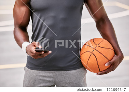 Closeup of a basketball player texting on a phone while taking a break from playing a match on a sports court outside. Hands of one male athlete browsing social media online during a game interval 121094847