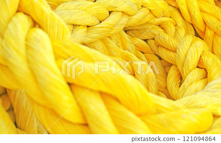 Yellow rope. Strong thick braided colorful rope woven and twined. Yellow thick rope macro closeup laying in a heap. Long twisted strong material symbolizes unity, togetherness, and teamwork. Yellow rope. Strong thick braided colorful rope woven and twined. Yellow thick rope macro closeup laying in a heap. Long twisted strong material symbolizes unity, togetherness, and teamwork. 121094864