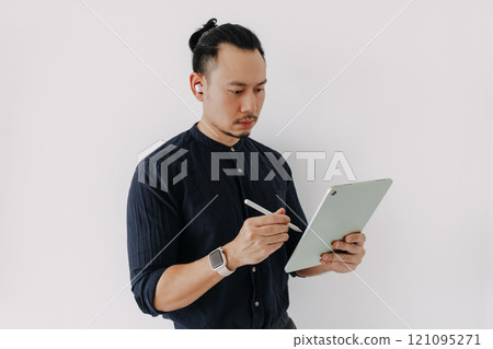 Creative freelance man with earbuds work with tablet isolate on white. Creative freelance man with earbuds work with tablet isolate on white. 121095271