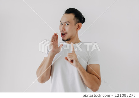 Funny tricky face man telling secret in white t-shirt isolate on white. 121095275