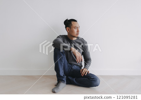 Lonely Freelance creative man sitting alone in empty white room. Lonely Freelance creative man sitting alone in empty white room. 121095281