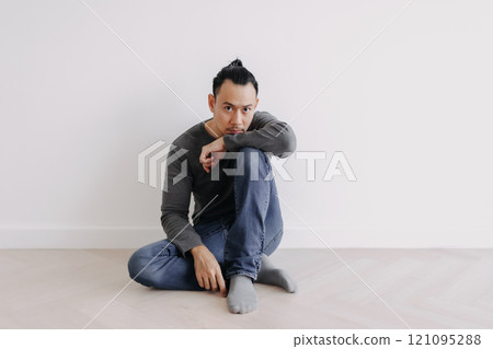 Lonely Freelance creative man sitting alone in empty white room. 121095288