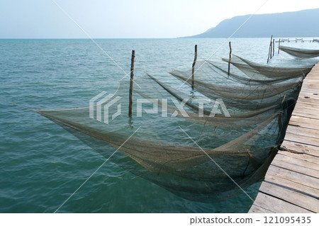 Fishing nets for catching fish in the sea and ocean. Fishing nets on a ship. Texture of fishing nets. Fishing nets for catching fish in the sea and ocean. Fishing nets on a ship. Texture of fishing nets. 121095435