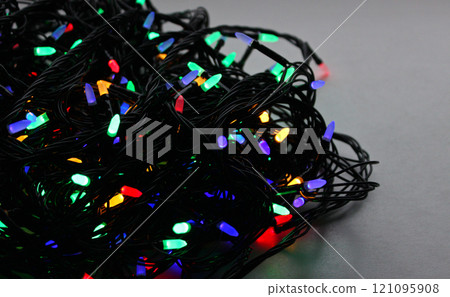 Scroll of Tangled Wires Garland with Burning Multi Colored Bulbs. Holiday Decorative Garland Closeup Image with Copy Space 121095908