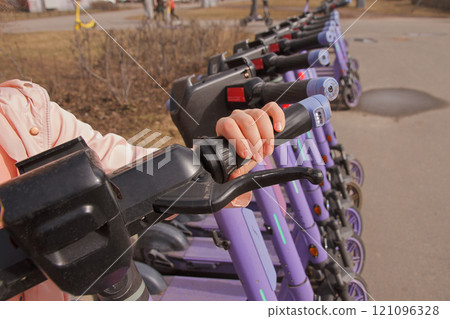 child's hands on steering wheel of an electric scooter electric scooter park , rental service child's hands on steering wheel of an electric scooter electric scooter park , rental service 121096328
