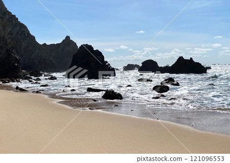 Empty wild sandy beach, Atlantic Ocean seascape, sea waves, beautiful cloudscape, dramatic landscape, travel content, Lisbon, Portugal 121096553