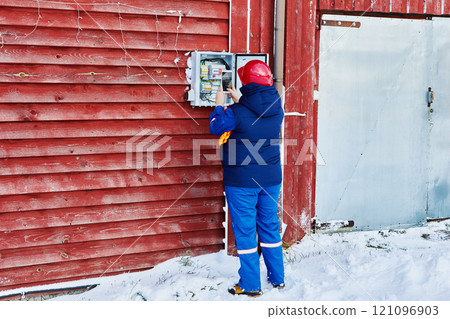 Scanning electric meter readings, power company engineer uses mobile device. 121096903