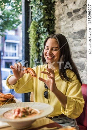 Woman enjoying traditional ecuadorian shrimp meal in madrid restaurant 121096997