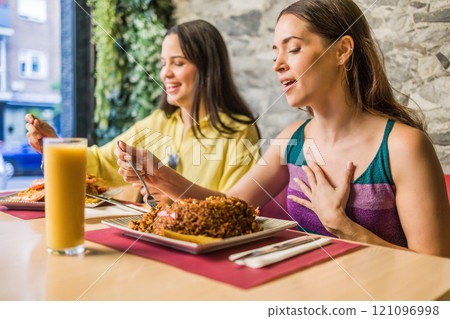 Women enjoying traditional ecuadorian food in madrid restaurant 121096998
