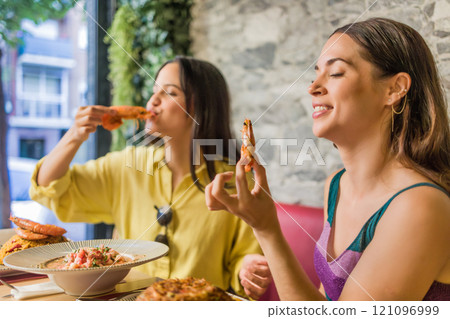 Women enjoying traditional ecuadorian shrimps in madrid restaurant 121096999