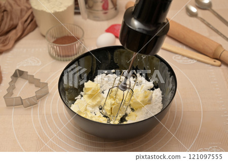 Christmas homemade baking, ingredients for baking gingerbread, mixing sugar powder and butter in black bowl 121097555