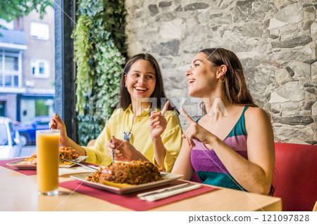 Latinx female friends together eating happy in a Ecuadorian food restaurant. Traditional meal Latinx female friends together eating happy in a Ecuadorian food restaurant. Traditional meal 121097828
