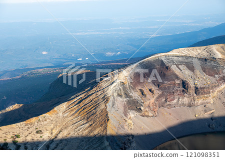 Zao mountain Yamagata Japan, Volcanic landscape with distant city view under blue sky. Zao mountain Yamagata Japan, Volcanic landscape with distant city view under blue sky. 121098351