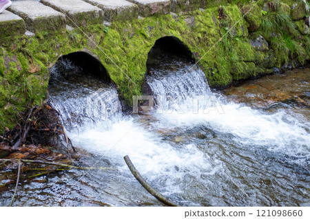 Ginzan onsen, Yamagata, Japan, Water flowing from moss-covered drainage pipes into a stream Ginzan onsen, Yamagata, Japan, Water flowing from moss-covered drainage pipes into a stream 121098660