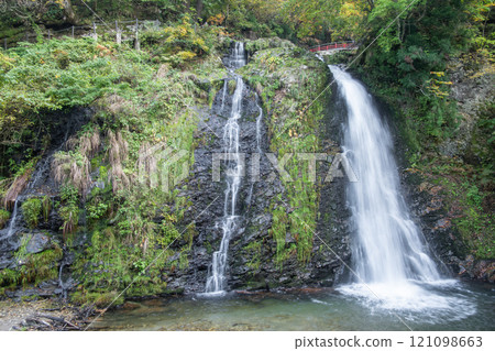 Ginzan onsen, Yamagata, Japan, Serene waterfall cascading over lush greenery. Ginzan onsen, Yamagata, Japan, Serene waterfall cascading over lush greenery. 121098663