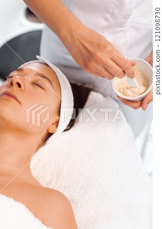 Dermatologist preparing face mask for female Dermatologist preparing face mask for female 121098730