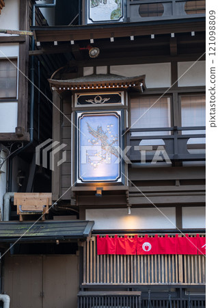 Ginzan onsen, Yamagata, Japan ,Traditional building with a decorative sign and red fabric banner. 121098809
