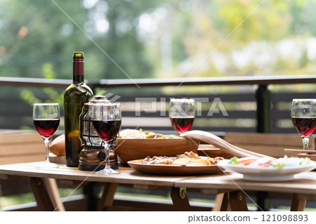 Image of wine, party food and home party on a wooden deck table 121098893
