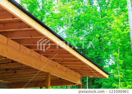Construction wooden frame overhang showcases craftsmanship during new home creating peaceful outdoor atmosphere. 121098961