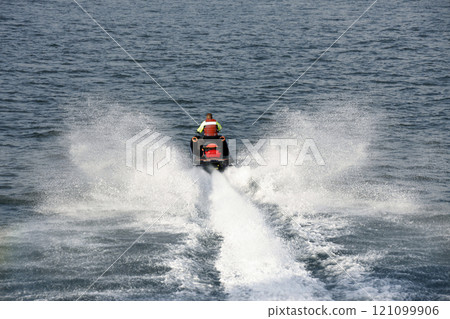 摩托艇前進，猛烈地濺起水花。看起來很舒服的水上運動 121099906