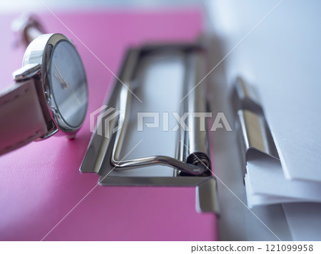 Binders, documents and a watch on a table 121099958