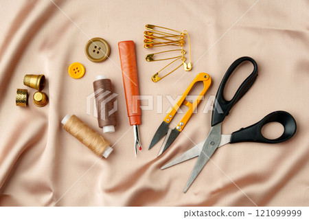Sewing tools and materials arranged on soft fabric showcasing essential crafting supplies for creative projects 121099999