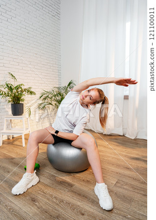 A woman stretching sideways in a bright, minimalist room 121100011